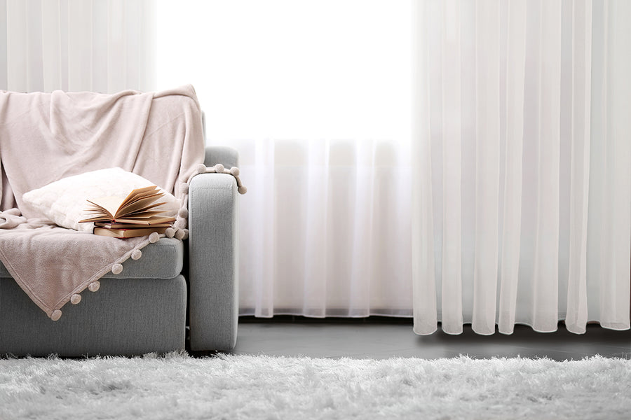 Bari jacquard sheer grommet curtain in white, styled at a window