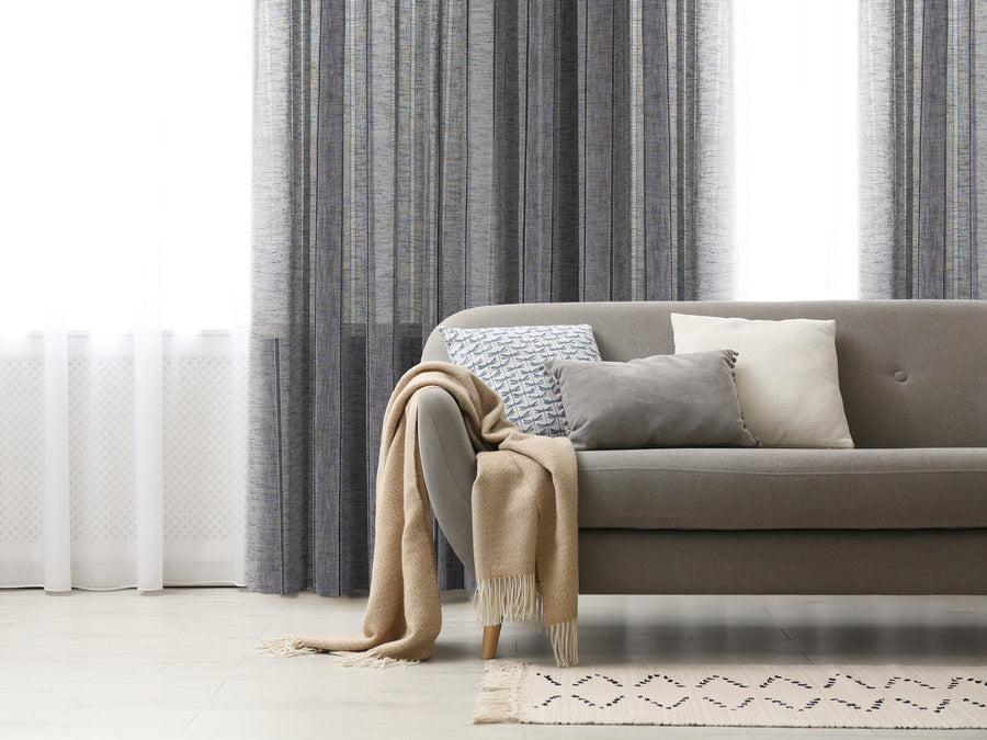 Boca jacquard semi sheer grommet curtain in blue, styled at a window