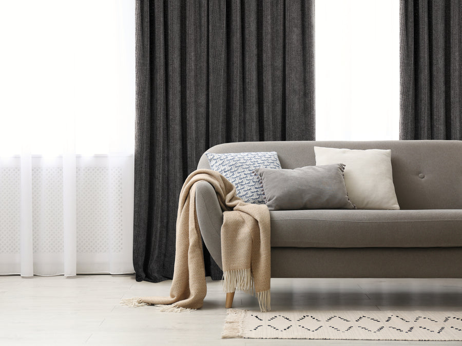 Casablanca chenille light filtering reverse tab curtain in charcoal, styled at a window