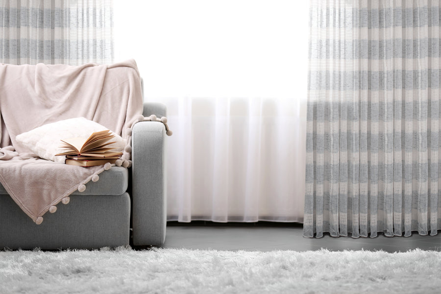 Geneva jacquard sheer grommet curtain in grey, styled at a window