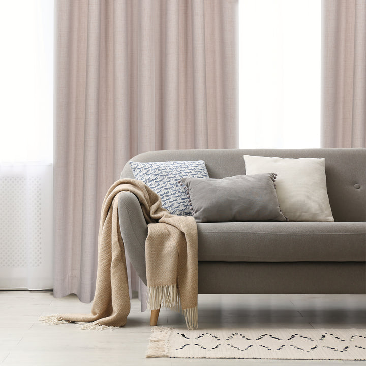 Malta textured blackout grommet curtain in rose, styled at a window