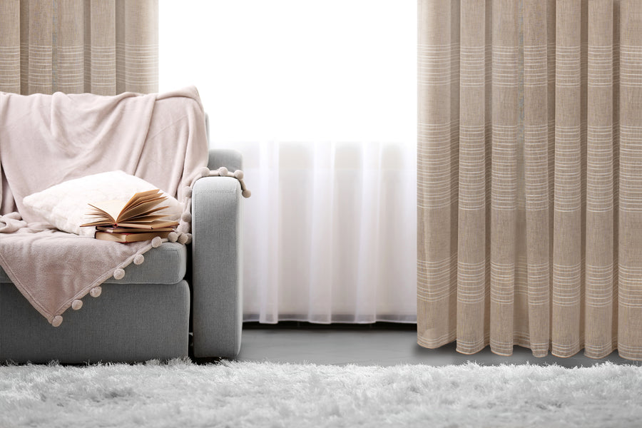 Mykonos horizontal striped jacquard sheer grommet curtain in taupe, styled at a window
