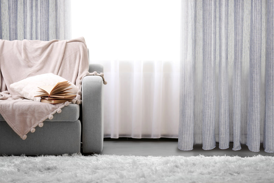 Nobile striped jacquard sheer grommet curtain in navy, styled at a window