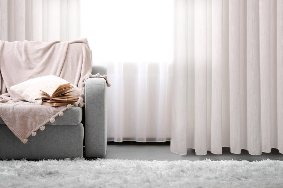 Novara textured jacquard semi sheer grommet curtain in white, styled at a window