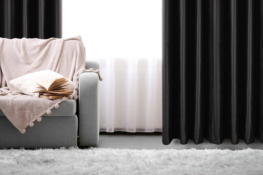 Heavy velvet textured curtain in black, styled at a window